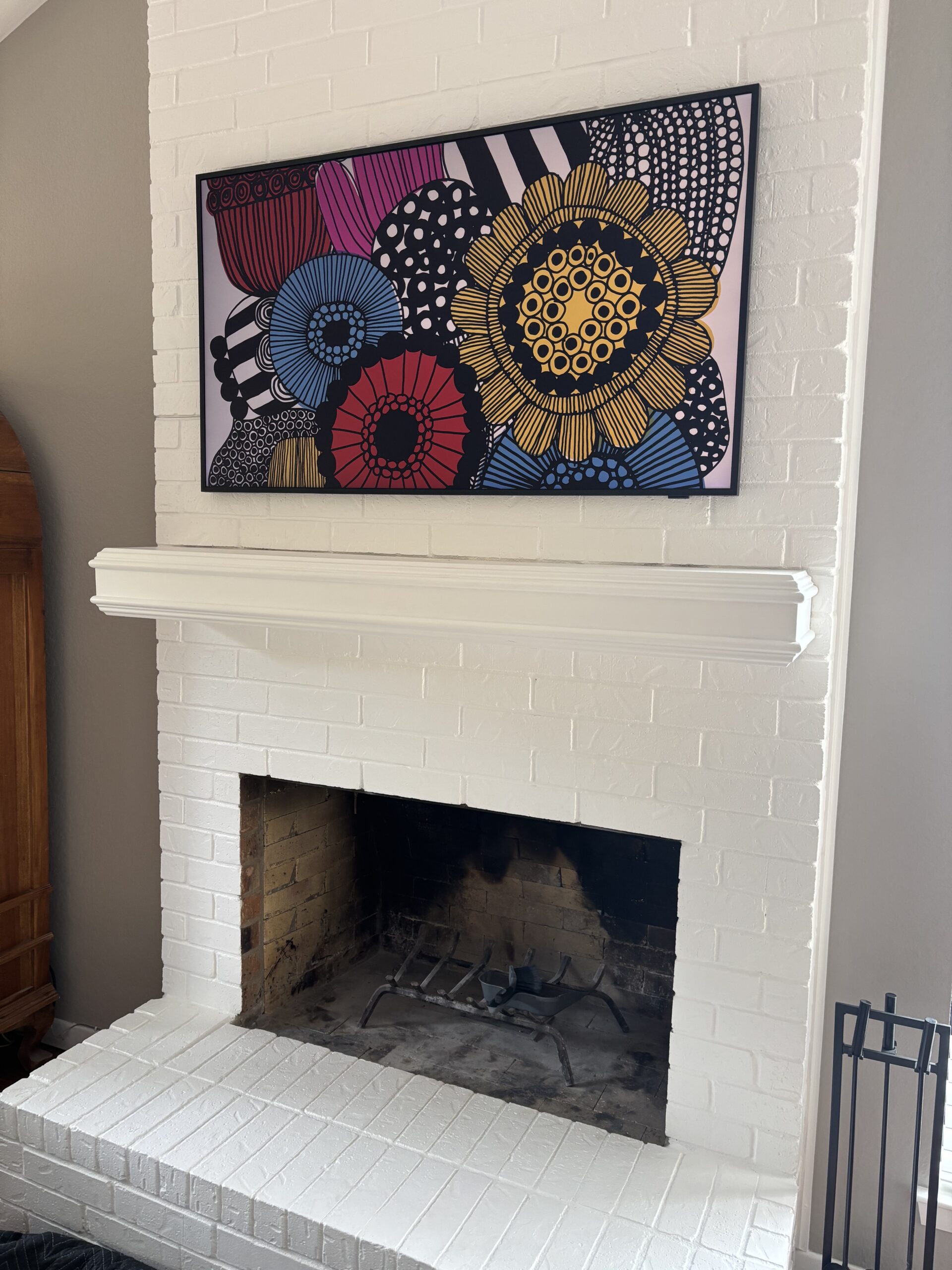 50 inch Samsung Frame TV over white brick fireplace with art mode in Round Rock TX