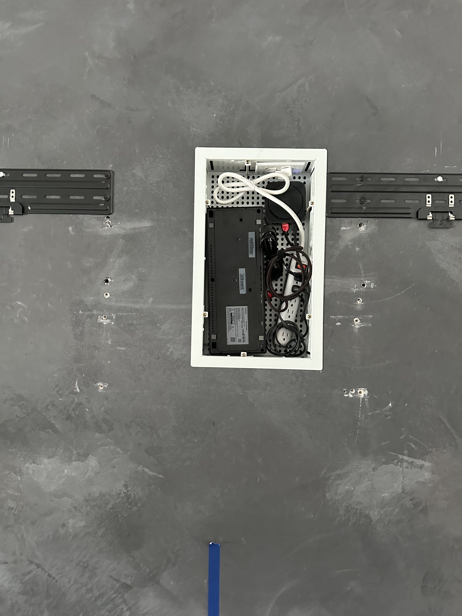 Recessed wall box installed into faux stone fireplace for Samsung Frame TV One Connect cord concealment Austin TX